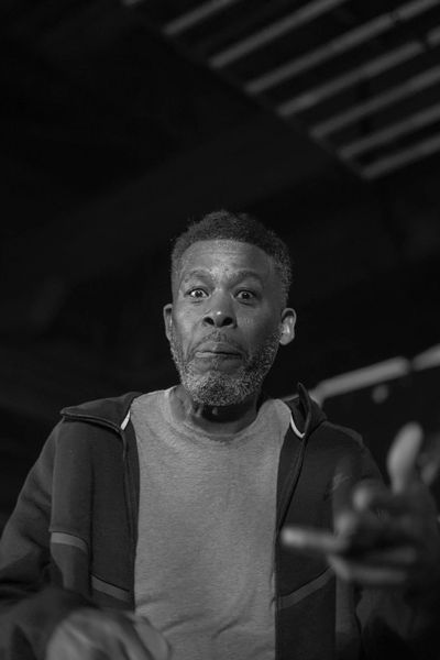 Close-up of GZA mid-verse, sweat and stage lights visible, Charleston concert photography