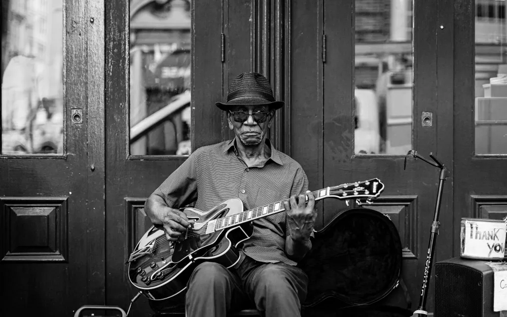 Philadelphia street musician playing guitar in a doorway, black and white portrait