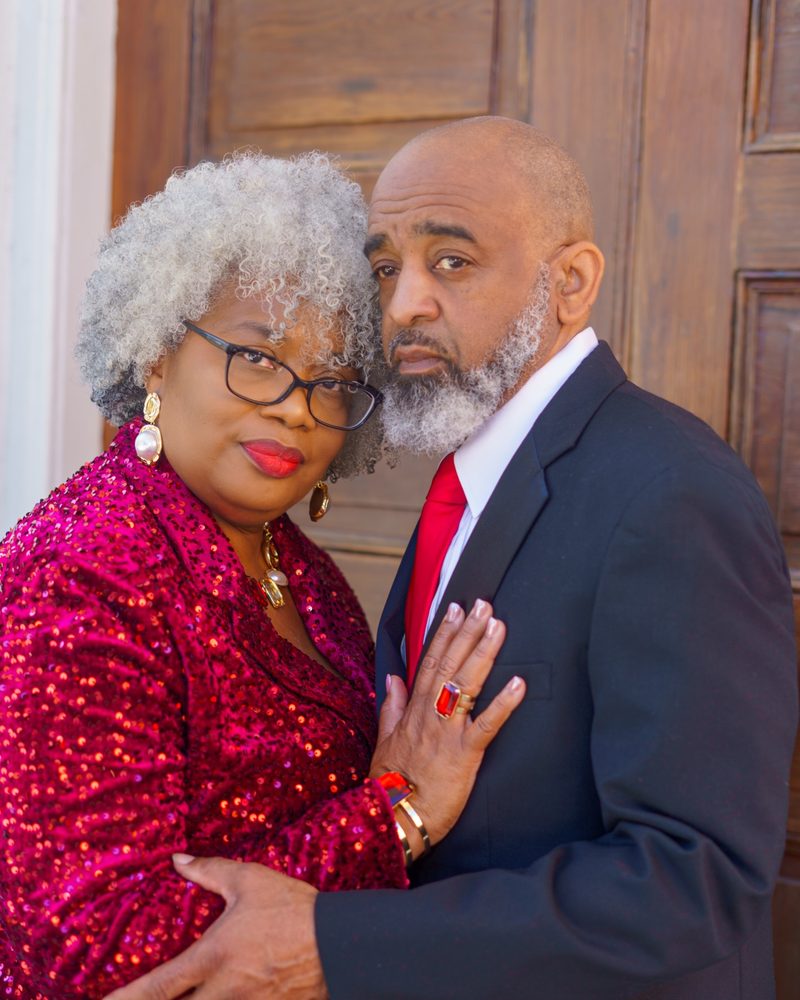 Close intimate anniversary portrait, red sequin dress against dark suit