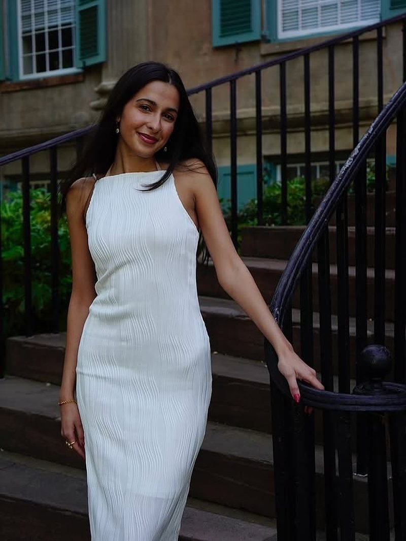 Graduate in white on historic Charleston steps with wrought iron railing