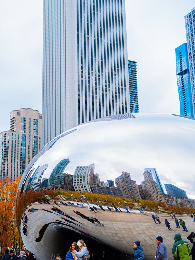 Cloud Gate sculpture reflecting the Chicago skyline and autumn trees in Millennium Park