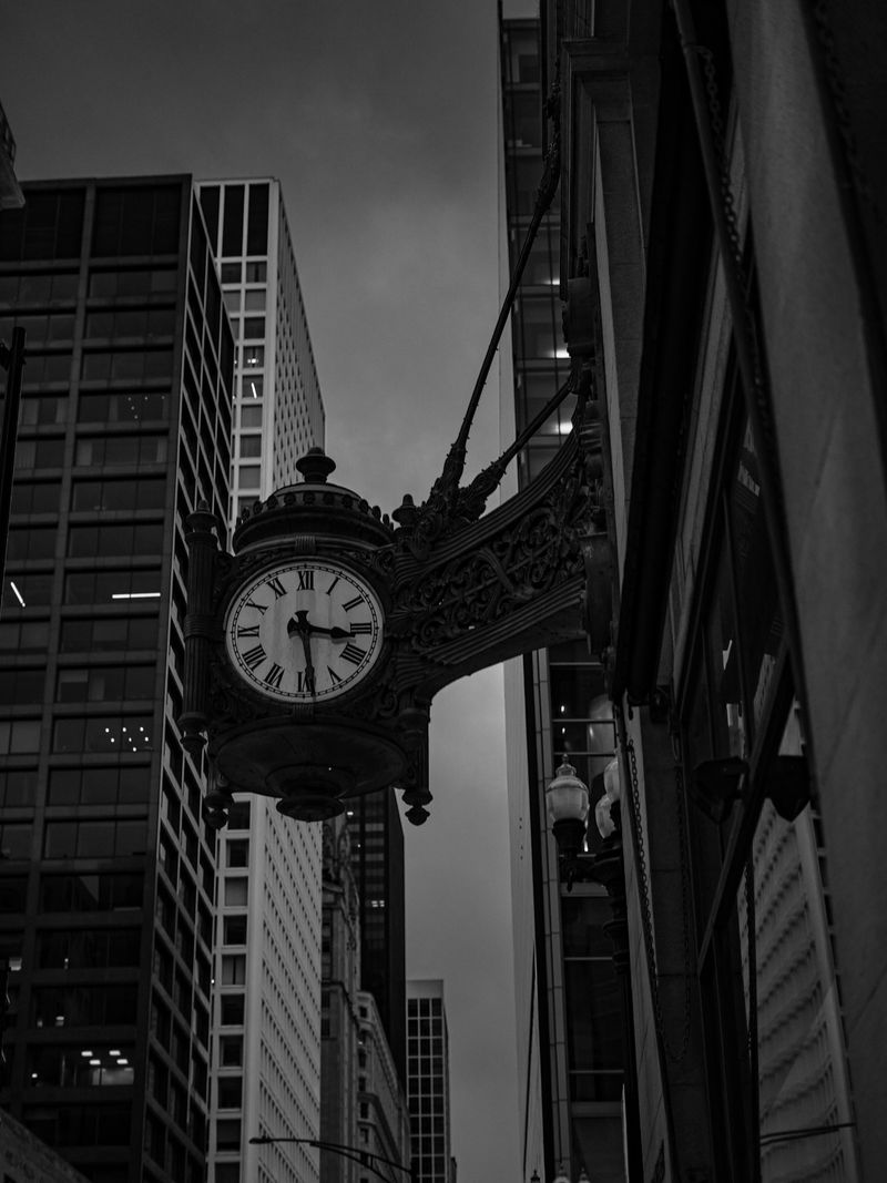 Historic Marshall Field's clock on State Street in Chicago, shot in black and white against modern towers