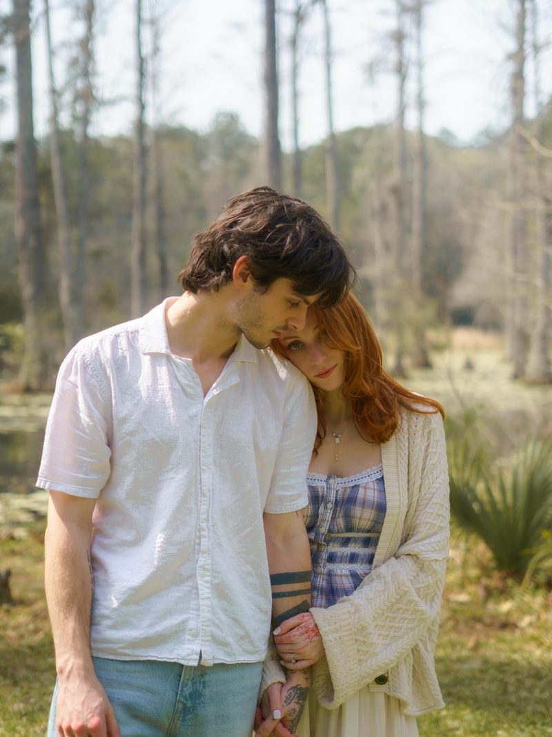 Close intimate portrait of an engaged couple in the soft filtered light near the Cypress Gardens butterfly house