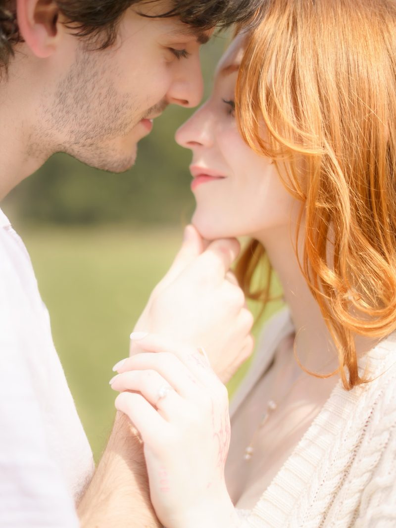 Close-up of a newly engaged couple face to face, ring visible, at Cypress Gardens
