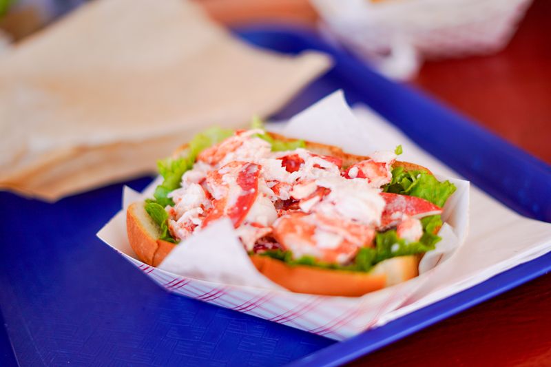 Fresh lobster roll on a paper-lined tray at a Maine seafood shack