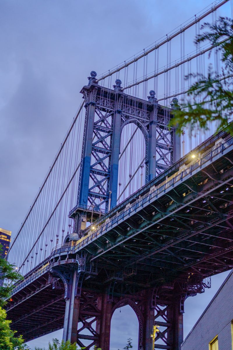 Manhattan Bridge suspension cables and steel trestle work shot from directly below at dusk