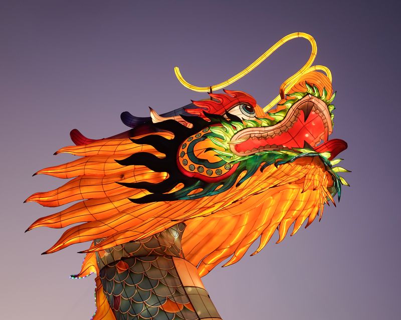 Illuminated dragon lantern sculpture in Philadelphia's Chinatown at dusk