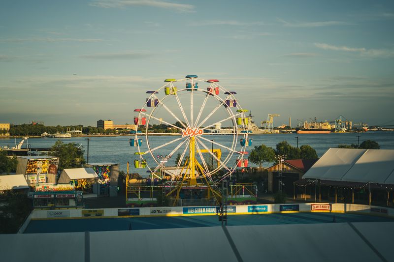 Ferris wheel and waterfront carnival at Penn's Landing in Philadelphia at golden hour