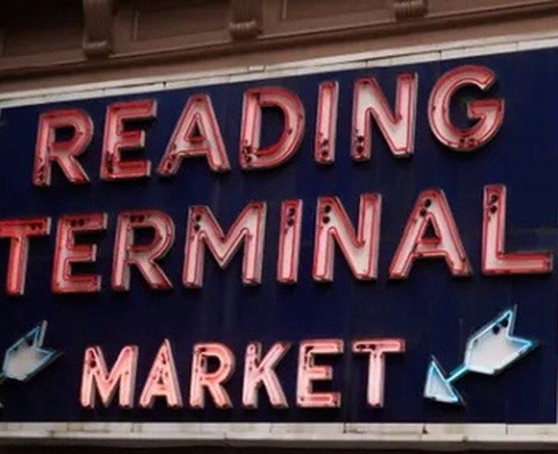 Neon Reading Terminal Market sign against the building facade