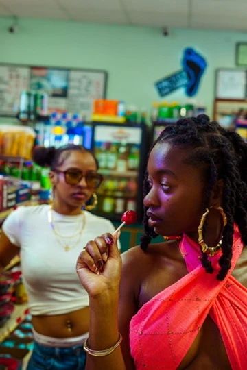 Candid moment between two models among store shelving, editorial photography