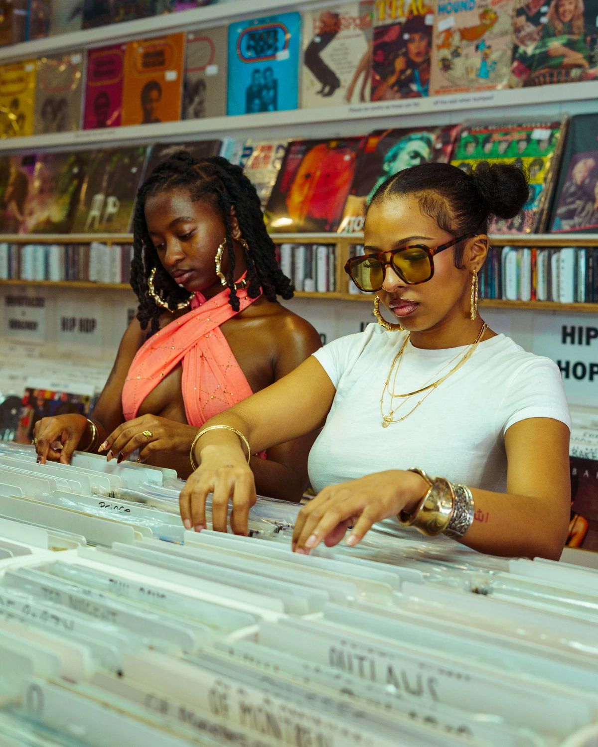 Two models flipping through vinyl records in a Charleston record store, editorial fashion photography