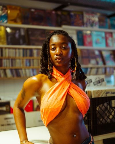 Editorial portrait in a record store with vinyl shelves in the background