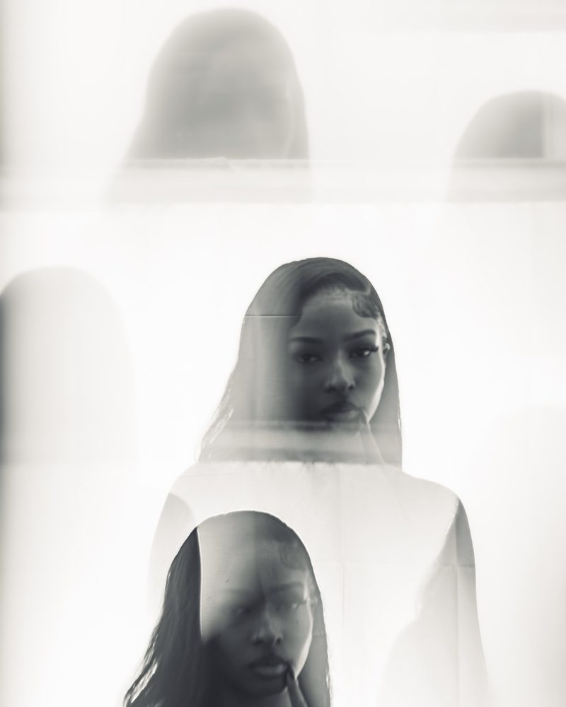 Layered double-exposure black and white studio portrait